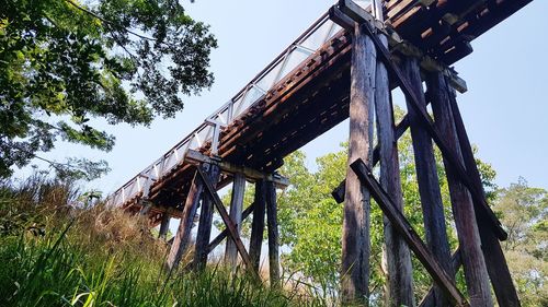 Low angle view of rusty metallic structure on field against sky