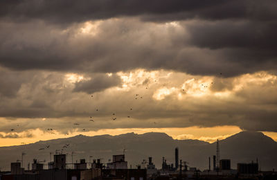 Silhouette buildings against sky during sunset