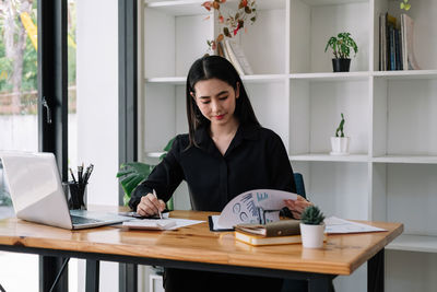Portrait of young woman using laptop at home