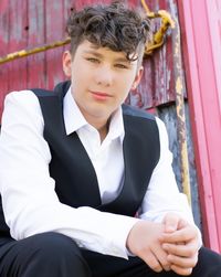 Portrait of young man standing against wall