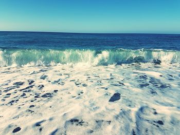 View of calm beach against clear sky