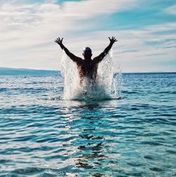 Man surfing in swimming pool in sea against sky