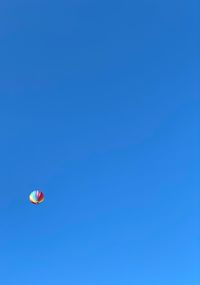 Low angle view of hot air balloon against clear blue sky