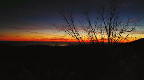 Scenic view of silhouette land against sky at sunset