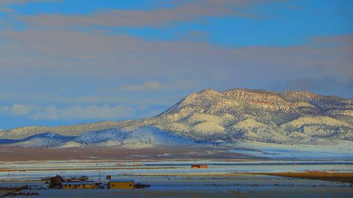 Scenic view of sea and mountains against sky