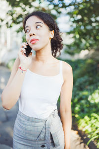 Young african woman speaking on mobile phone. white t shirt mockup