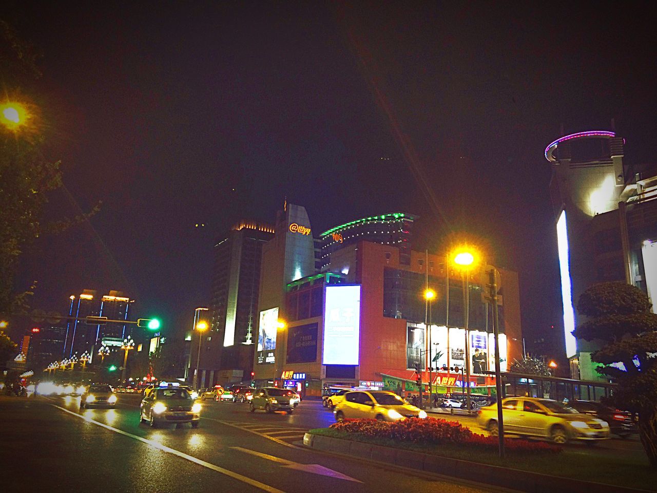 illuminated, night, building exterior, architecture, city, street light, built structure, street, transportation, car, lighting equipment, road, traffic, city street, land vehicle, city life, long exposure, sky, mode of transport, light - natural phenomenon