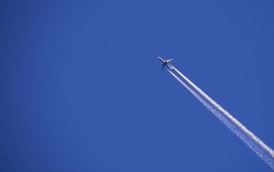 Low angle view of airplane flying in clear blue sky