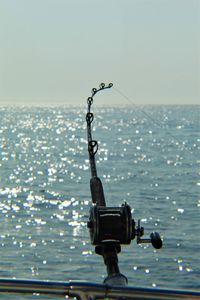 Close-up of camera against sea against clear sky