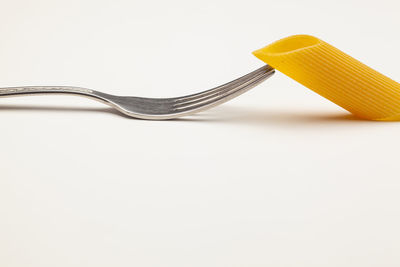 High angle view of fork on table against white background