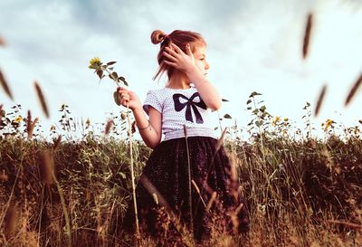 Full length of girl standing on field against sky