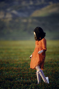 Rear view of woman standing on field