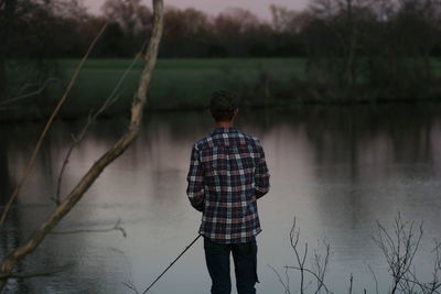 Rear view of man fishing in lake