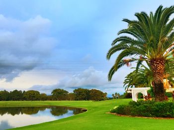 Scenic view of green landscape against cloudy sky