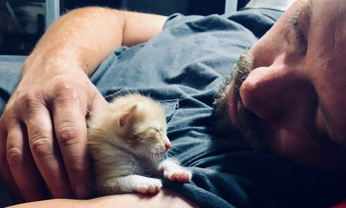 Midsection of man sleeping on bed