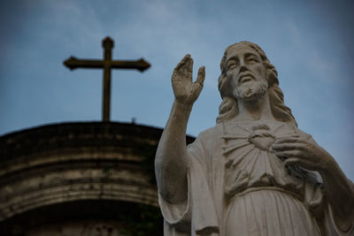 Low angle view of statue against temple against sky