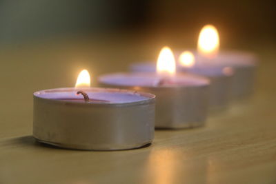 Close-up of illuminated tea light candles on table