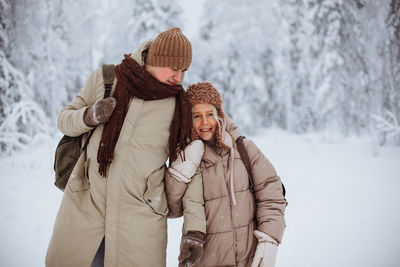 Couple in love walks through the winter forest