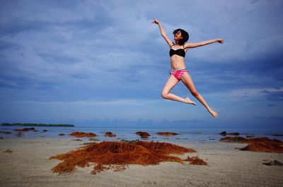 Woman jumping on shore