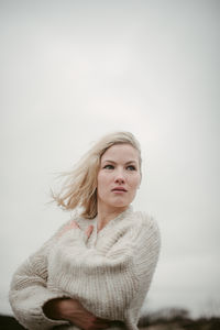 Portrait of beautiful woman against sky during winter