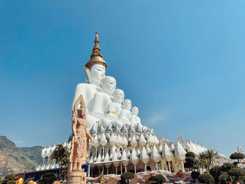 Low angle view of statue against building against sky