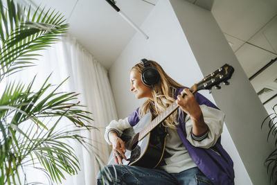 Guitarist wearing headphones playing guitar in studio