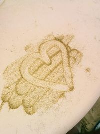 High angle view of heart shape drawn on sand