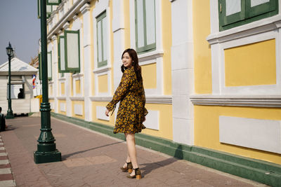 Portrait of woman standing against building