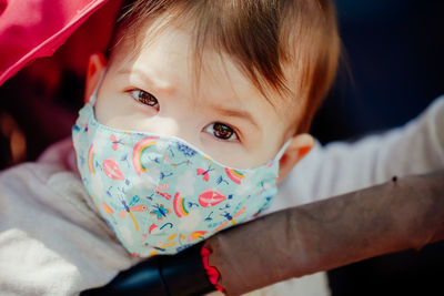 Close-up portrait of cute baby girl wearing mask