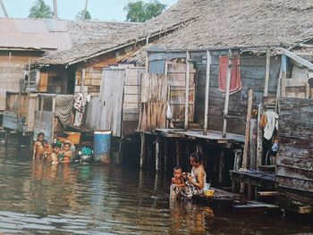 People on house by building