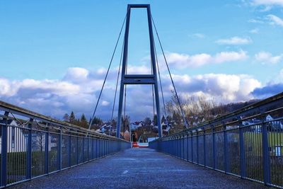 Bridge over road in city against sky