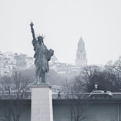 Statue in city against clear sky