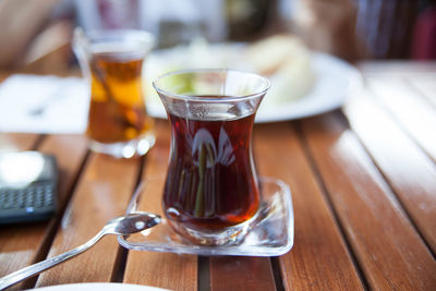 Black tea in glass on wooden table