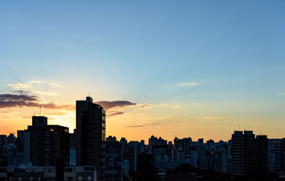 Silhouette buildings against sky during sunset