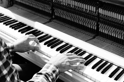 High angle view of man playing piano keys