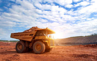 Built structure on dirt road against sky