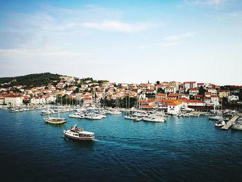 Boats in river with city in background