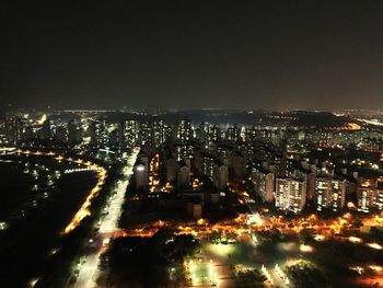 Illuminated cityscape against sky at night