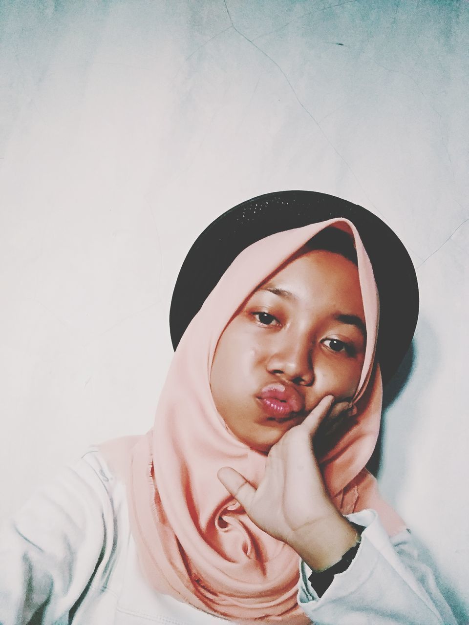 portrait, real people, front view, looking at camera, one person, lifestyles, young adult, headshot, young women, indoors, leisure activity, clothing, headscarf, wall - building feature, casual clothing, standing, looking, hood - clothing, scarf, beautiful woman, teenager