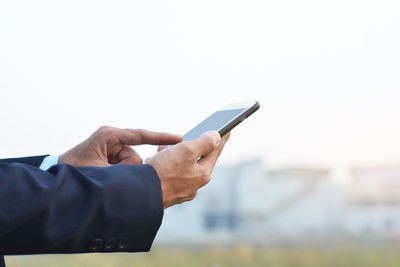 Midsection of man using mobile phone