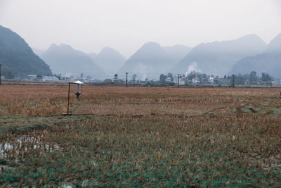 Scenic view of a village at the foot of the foggy mountains