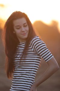 Beautiful young woman standing during sunset