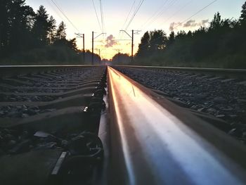 Railroad tracks against sky during sunset