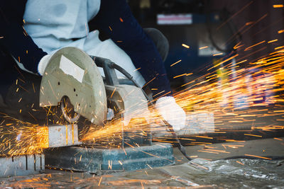 Cutting of a steel with splashes of sparks, industrial grinder with sparks flying off of the wheel