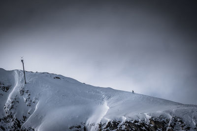 Low angle view of snow covered mountain against sky