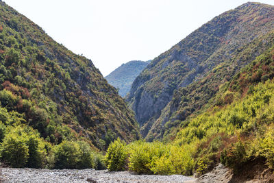 Scenic view of river amidst mountains against clear sky