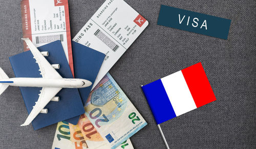 Flag of france with passport and toy airplane on wooden background. flight travel concept