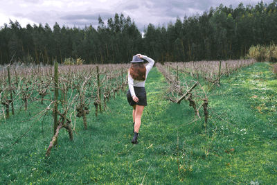 Rear view of woman walking on field