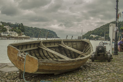 Boats in sea against cloudy sky