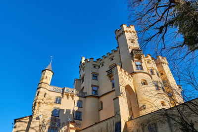 Low angle view of old building against clear blue sky